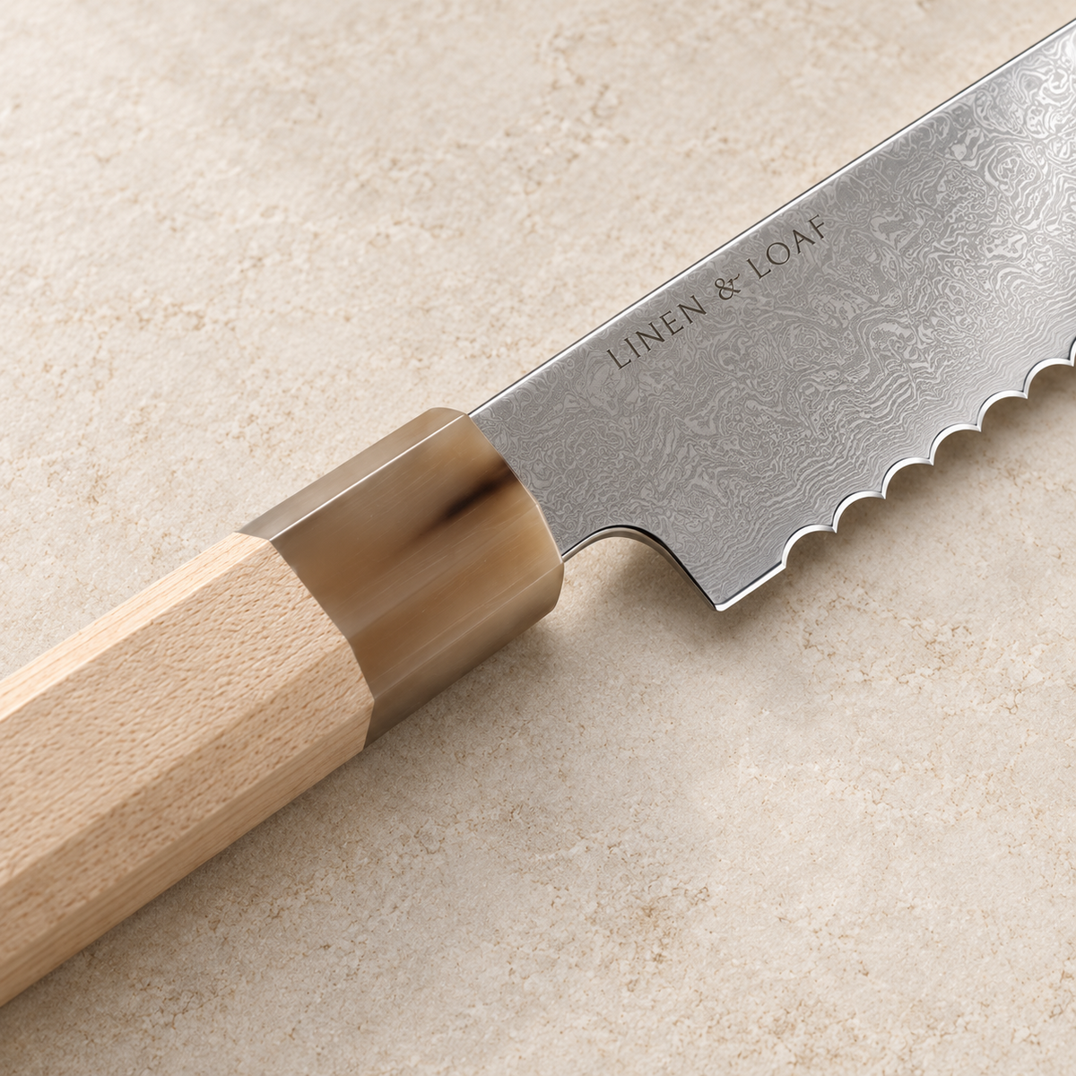 Close-up of Linen & Loaf Signature Bread Knife maple wood handle and natural white buffalo horn ferrule